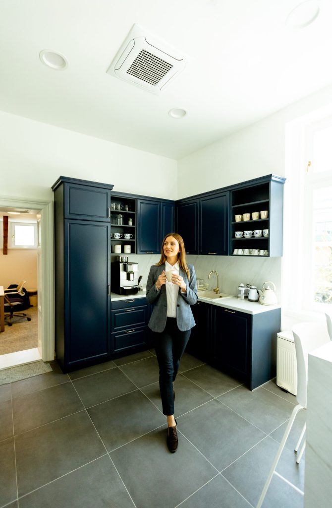 A woman stands confidently in a modern kitchen, focused on the stove top oven as she prepares a delicious meal with precision and passion.