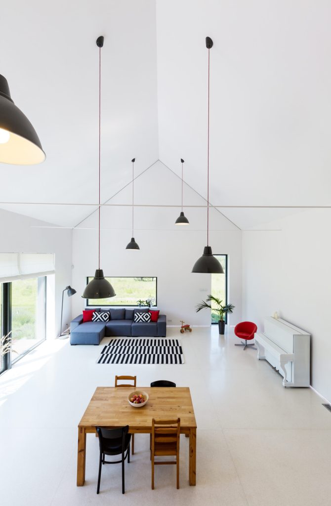 White spacious living room with table and sofa in a high room
